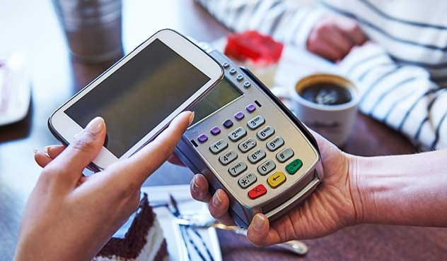Person paying with their phone on a wireless POS system