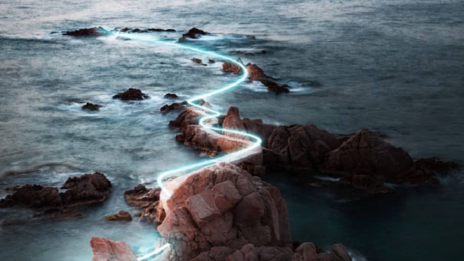 Bright light swirling over ocean rocks