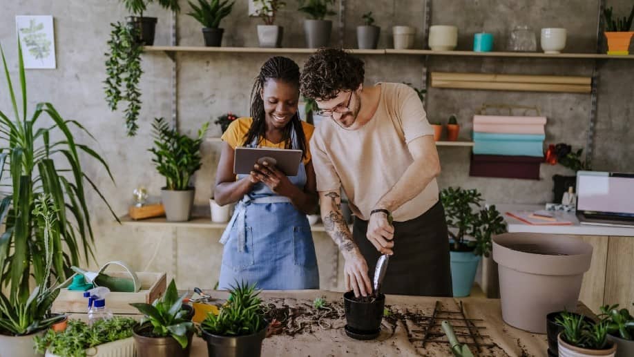 Man and woman working in a plant show and examining a tablet
