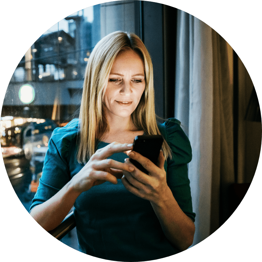 Woman smiling and holding smart phone.