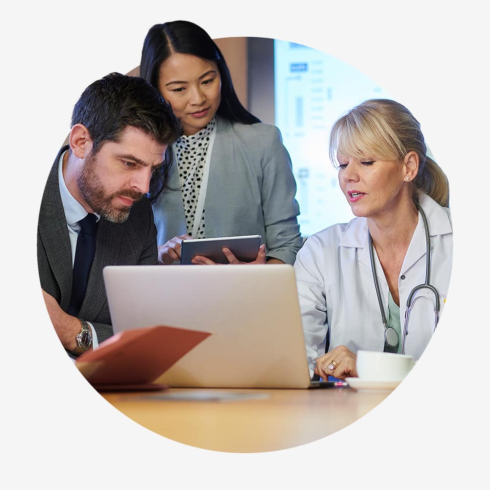 Three persons in front of a laptop computer