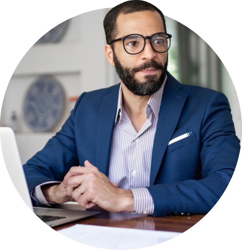 Man in suit sitting in front of a laptop computer