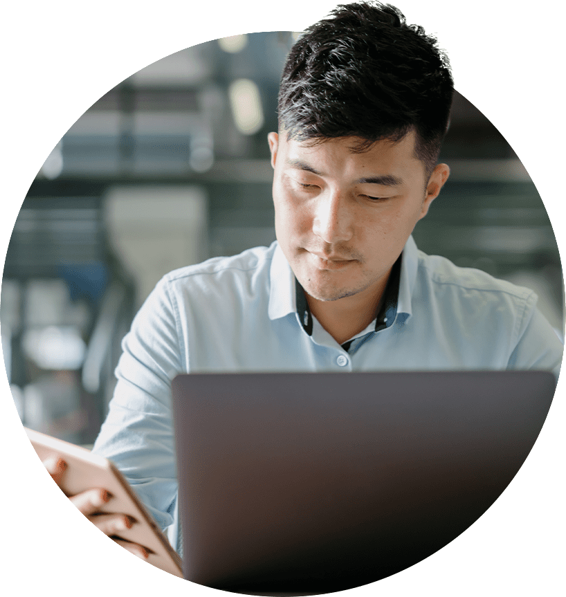 Man working in front of laptop and holding a smartphone