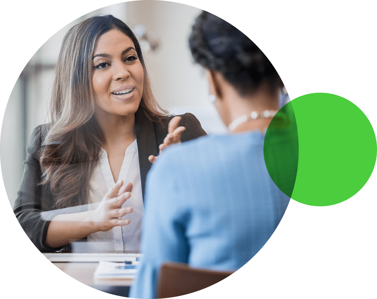 Two office colleagues sit across from one another having a discussion